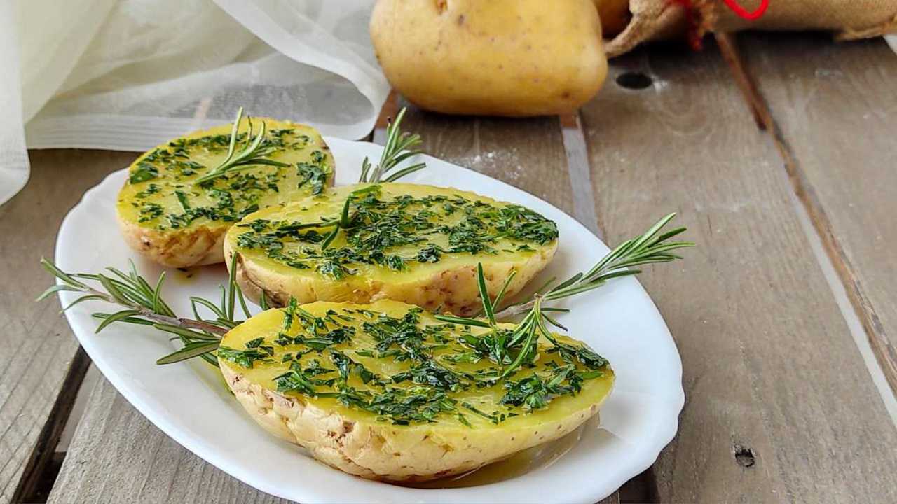patate cotte tagliate a metà con rosmarino, sale e olio