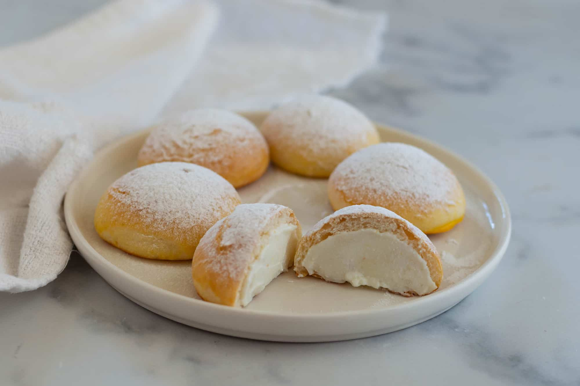 brioscine ripiene di crema di latte e ricotta su un piatto da portata