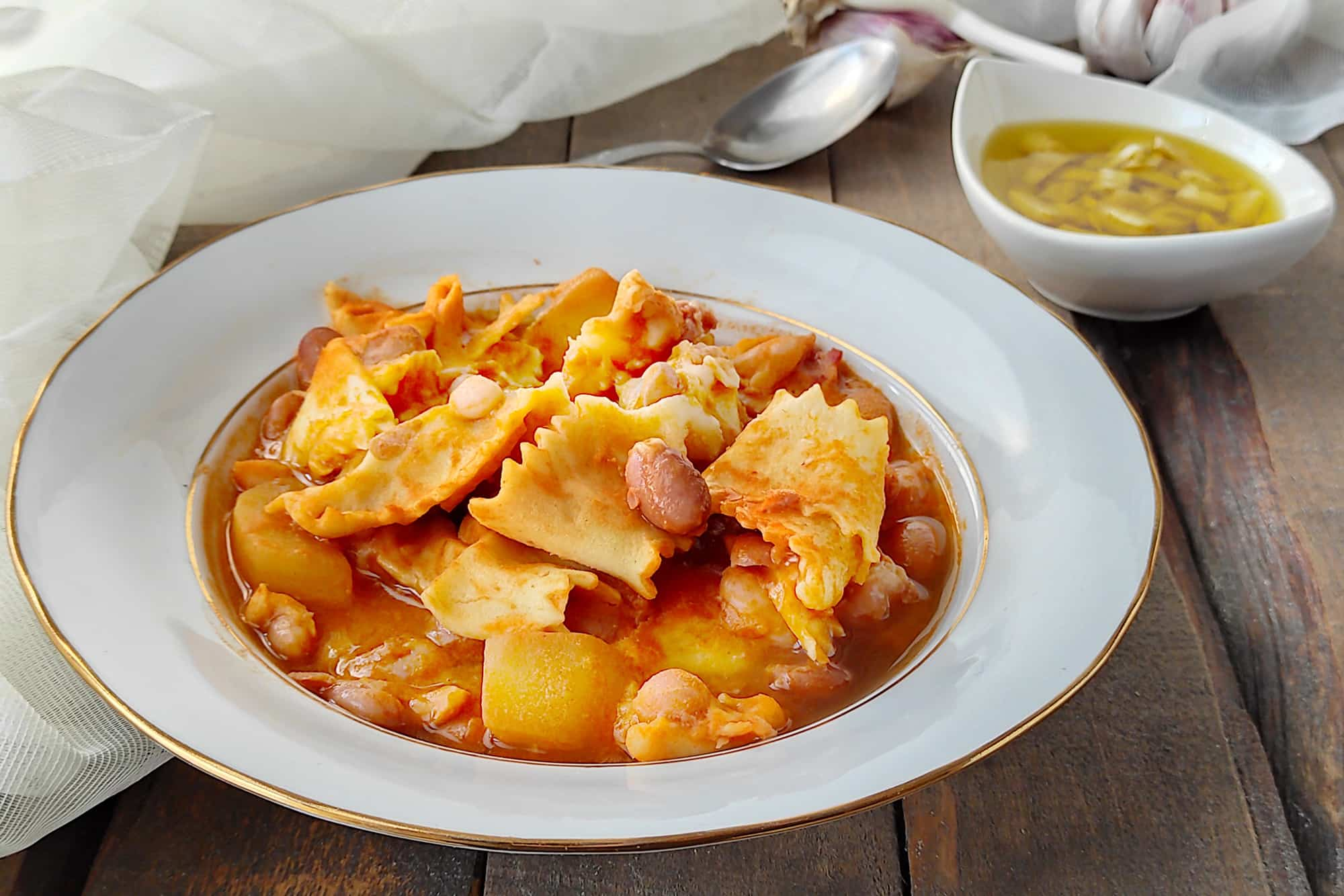 Piatto di Perbureira, ricetta tipica piemontese, con pasta all'uovo tipo lasagne e condimento a base di fagioli, patate e pancetta in brodo