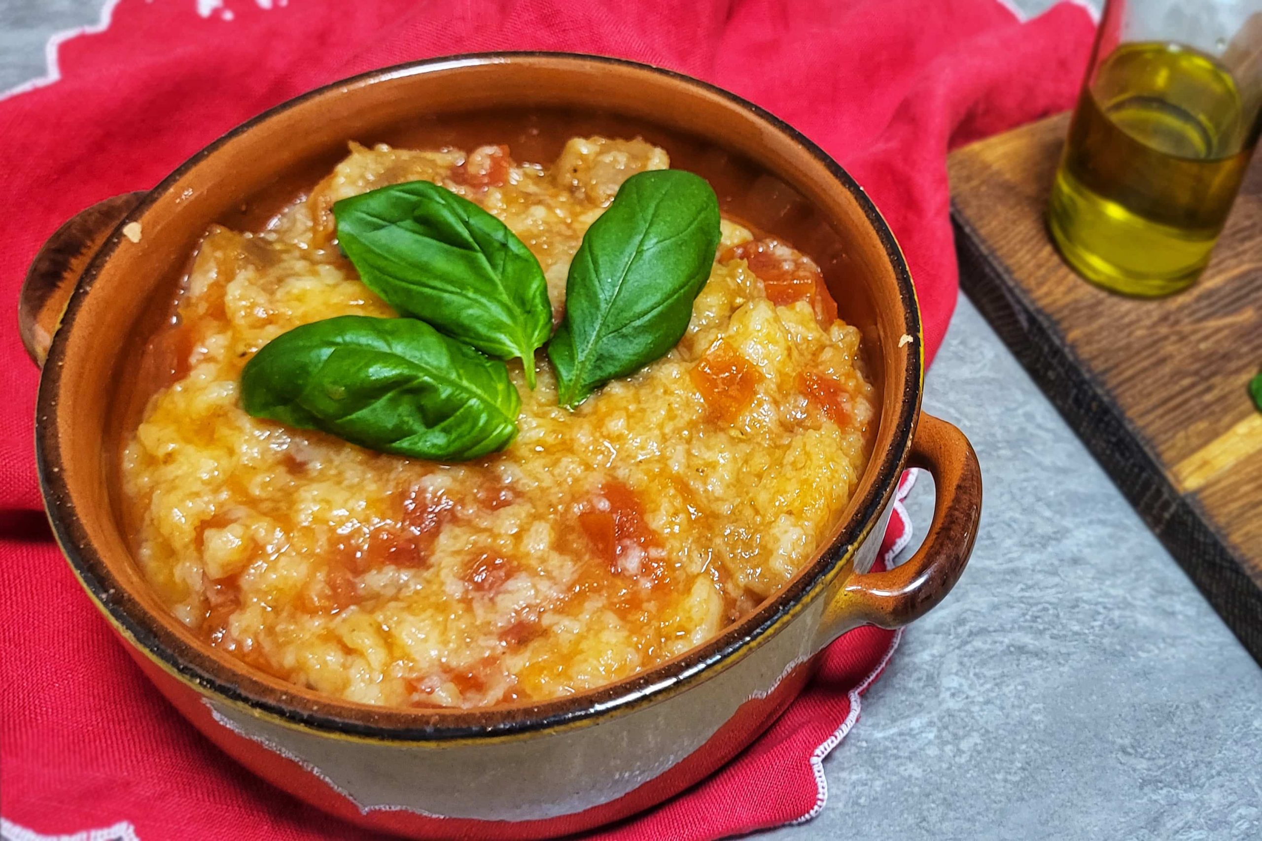 pentola di coccio con pappa al pomodoro toscana su canovaccio rosso