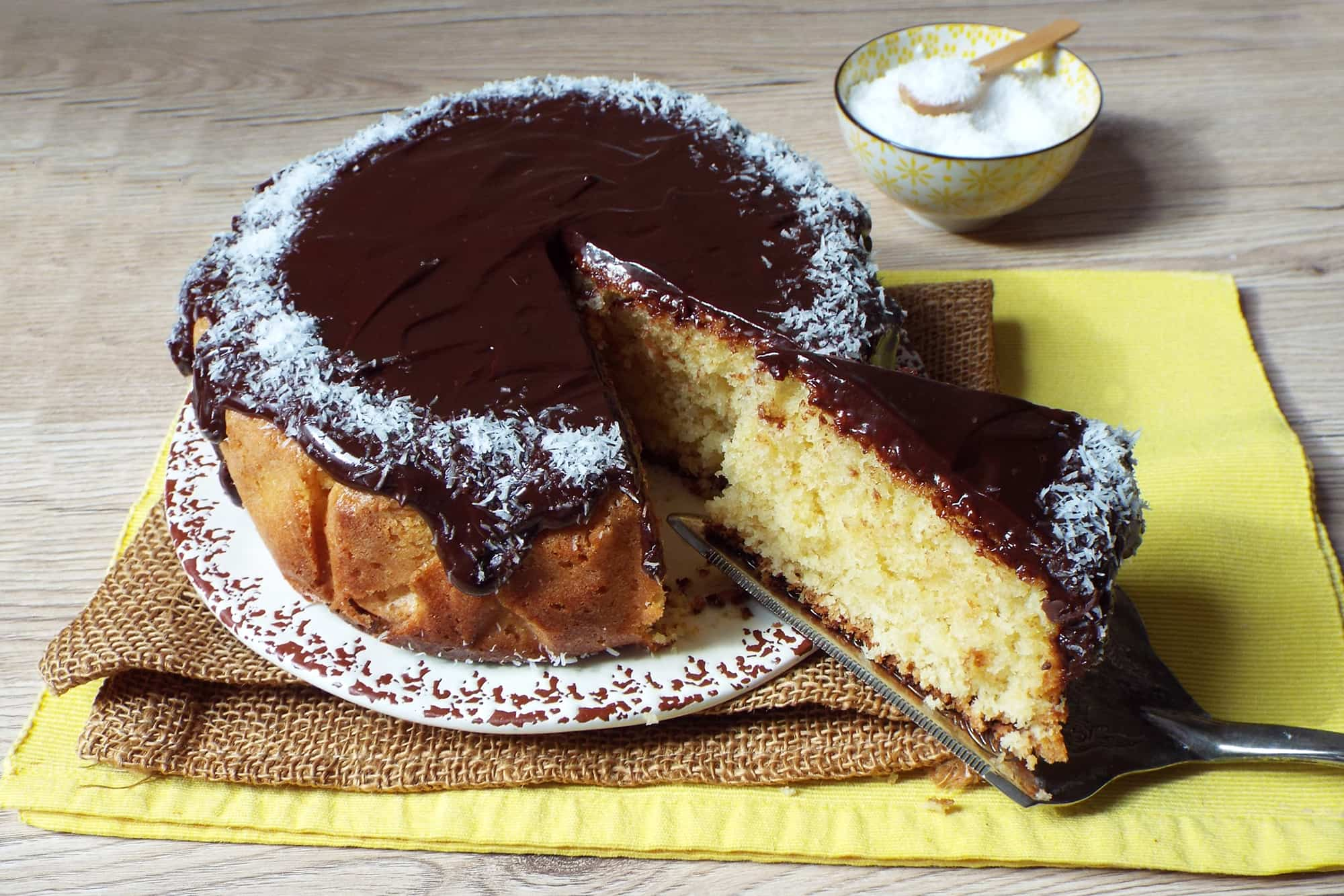 torta ricoperta di cioccolato e guarnita con cocco su una tovaglia gialla