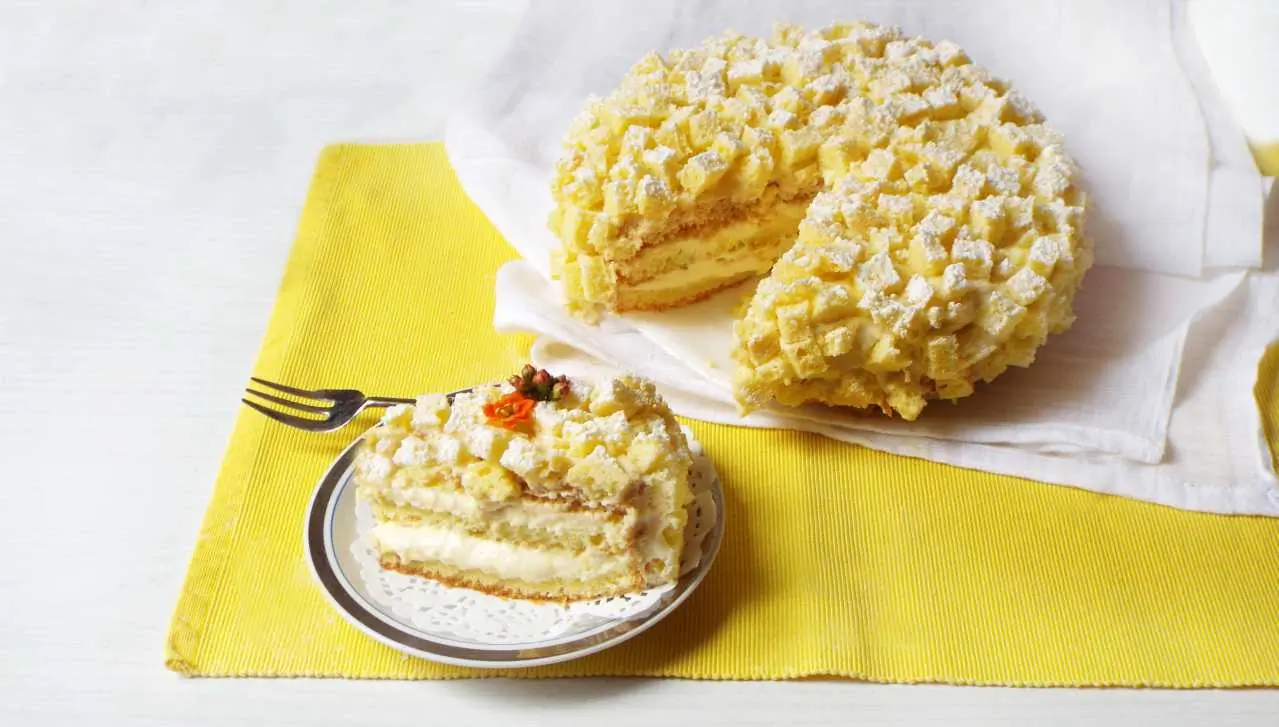 una torta mimosa con una fetta tagliata