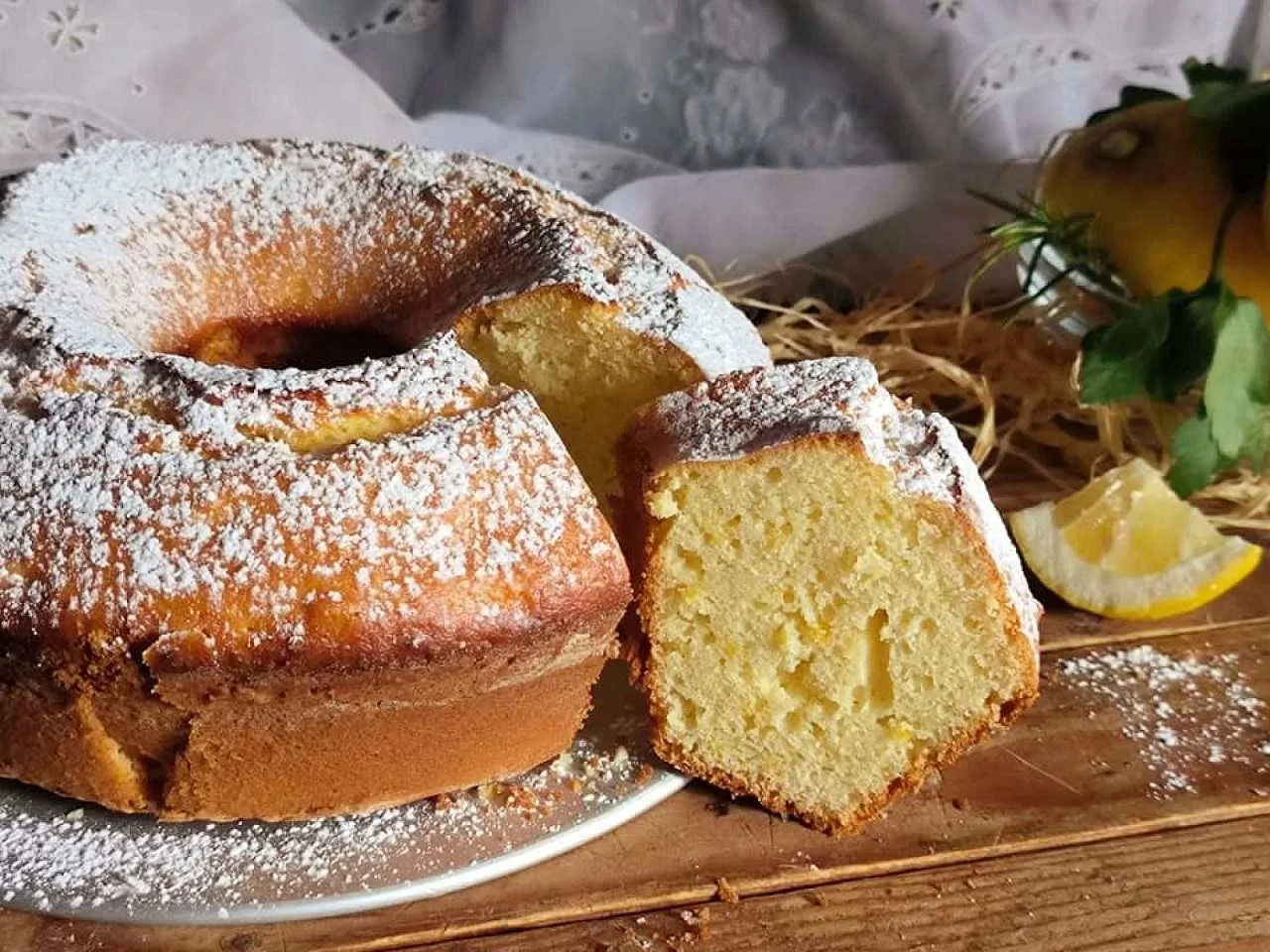 ciambella al limone soffice fatta in casa con fetta tagliata e zucchero a velo
