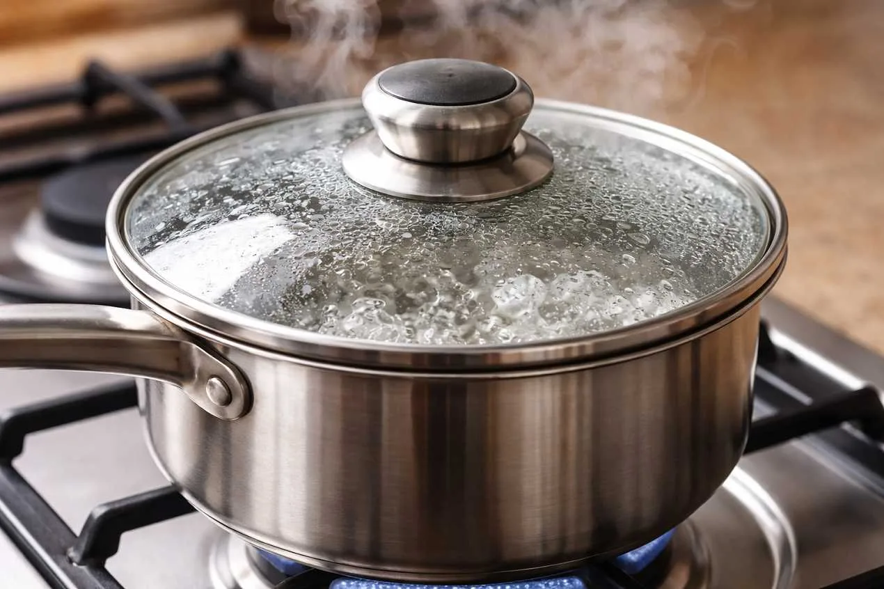 pentola con coperchio sul fornello durante la cottura dei cibi