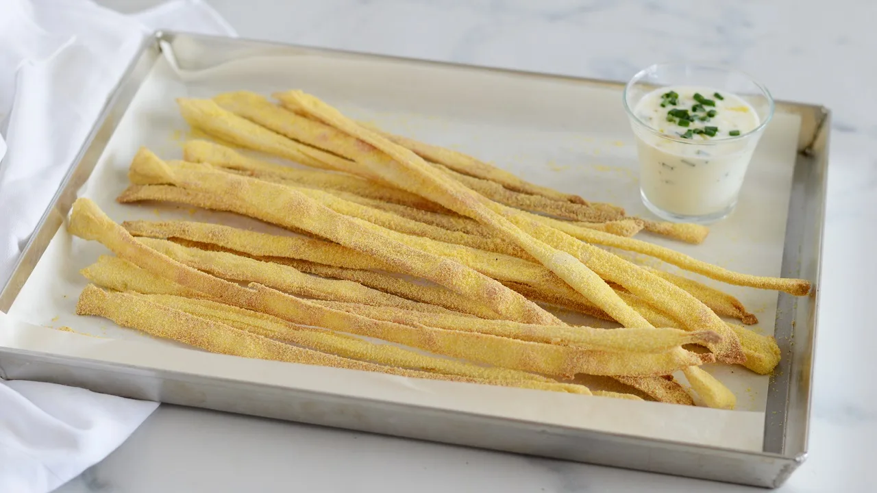 grissini fatti in casa croccanti appena sfornati disposti su un tagliere di legno