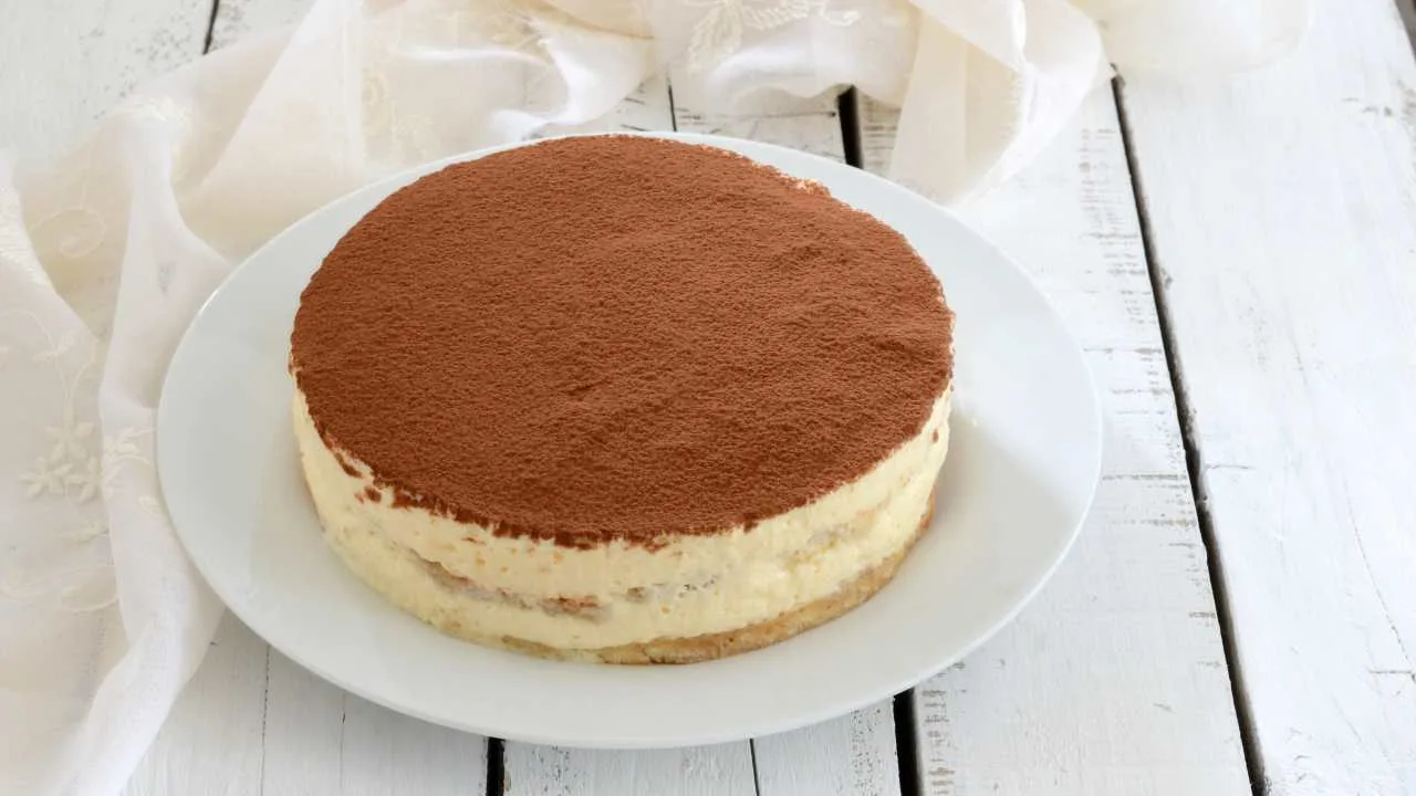 Fetta di torta tiramisù cremosa e compatta al taglio