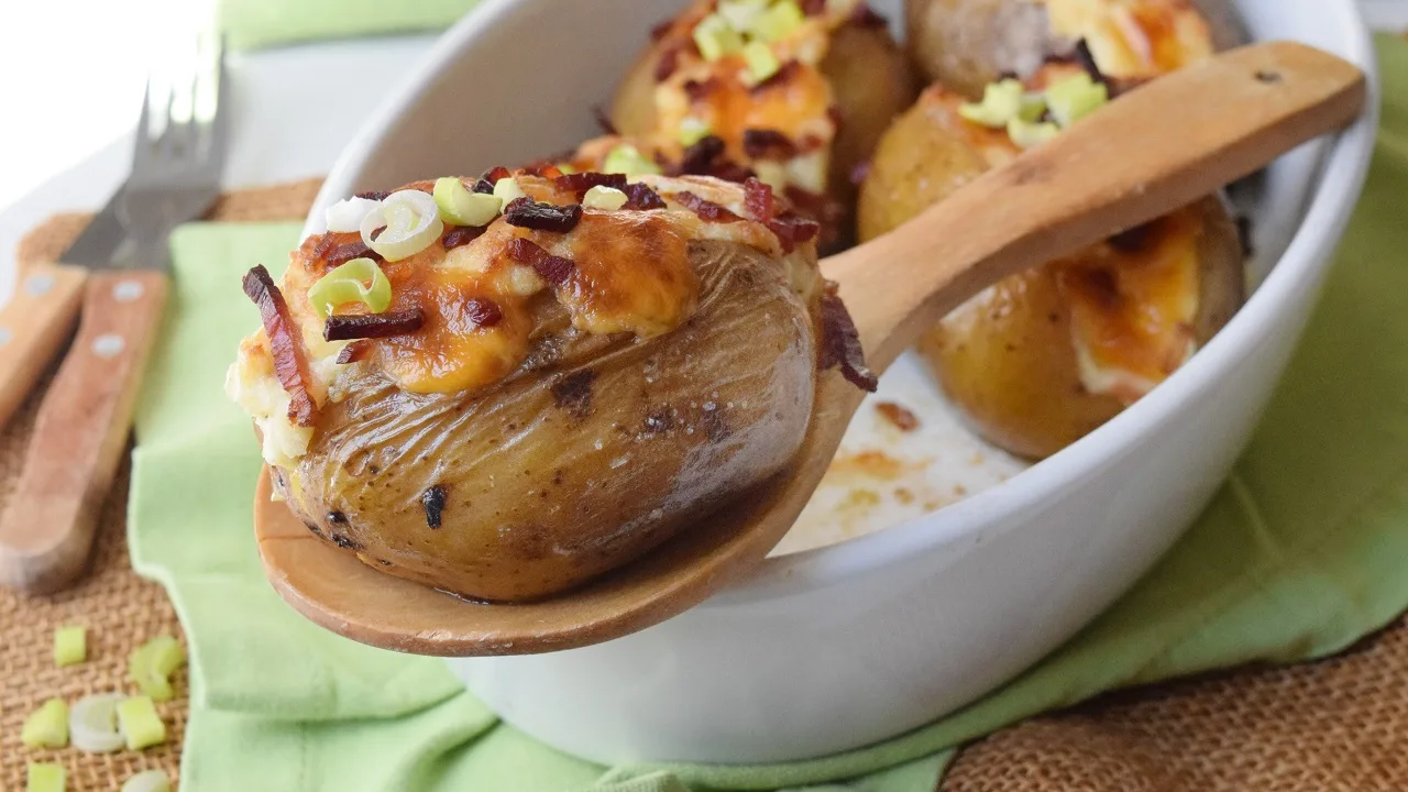 Patate al cartoccio farcite e filanti con formaggio gratinato e speck, servite calde